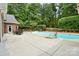 Inviting backyard oasis with a sparkling pool, patio area, and lush landscaping, perfect for entertaining at 1245 Bellemeade Ln, Charlotte, NC 28270