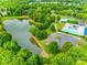 Aerial view of a community with pool, tennis courts, pond and playground amidst green trees at 1301 Cool Mist Ct, Indian Land, SC 29707
