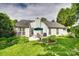 Beautiful backyard featuring a patio with an umbrella table and chairs, colorful flowerbeds, and lush greenery at 1301 Cool Mist Ct, Indian Land, SC 29707