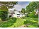 Spacious backyard featuring a well-maintained lawn, colorful flowerbeds, patio area and privacy landscaping at 1301 Cool Mist Ct, Indian Land, SC 29707