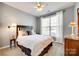 Cozy bedroom featuring a queen-sized bed, neutral walls, ceiling fan, and bright, natural light from the window at 1301 Cool Mist Ct, Indian Land, SC 29707