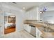 Bright kitchen featuring white cabinets, granite countertops, stainless steel dishwasher and tile backsplash at 1301 Cool Mist Ct, Indian Land, SC 29707