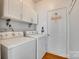 Practical laundry room with a washer, dryer, and white cabinets for storage at 1301 Cool Mist Ct, Indian Land, SC 29707