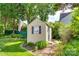 Backyard shed with blue shutters and adjacent garden, adding charm and functionality to the outdoor space at 1301 Cool Mist Ct, Indian Land, SC 29707