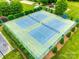 Aerial view of well-maintained tennis courts surrounded by lush green landscaping at 1301 Cool Mist Ct, Indian Land, SC 29707