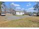 Expansive backyard featuring a well-maintained lawn, a large gravel area, and an overview of the surrounding trees at 1339 Hill St, Albemarle, NC 28001