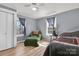 Bedroom with paneled walls, light-colored floors, a window, closet door, bed and an arm chair at 1339 Hill St, Albemarle, NC 28001