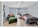 Bedroom with paneled walls, light-colored floors, a window, bed and an arm chair at 1339 Hill St, Albemarle, NC 28001
