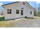 Rear exterior showcasing white siding, a gravel yard, and well-lit back door entrance at 1339 Hill St, Albemarle, NC 28001