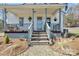 Welcoming front porch with a blue front door and hanging plants, leading up stone steps at 1339 Hill St, Albemarle, NC 28001