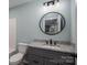 This bathroom features a modern vanity with granite countertop and a round mirror at 1428 E Main St, Cherryville, NC 28021