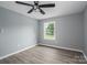 This bedroom features hardwood floors, a ceiling fan, and a window overlooking a wooded lot at 1428 E Main St, Cherryville, NC 28021