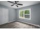 This bedroom features hardwood floors, a ceiling fan, and a window overlooking a wooded lot at 1428 E Main St, Cherryville, NC 28021
