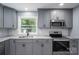 Modern kitchen featuring stainless steel appliances, gray cabinets, granite counters, and a window at 1428 E Main St, Cherryville, NC 28021