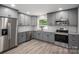 Beautifully renovated kitchen with stainless steel appliances, gray cabinetry, and granite countertops at 1428 E Main St, Cherryville, NC 28021