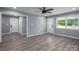 Bright living room featuring new gray wood-look flooring, gray paint, a window, and a ceiling fan at 1428 E Main St, Cherryville, NC 28021