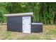Outdoor storage shed with single door in tree lined backyard at 1428 E Main St, Cherryville, NC 28021