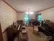 Cozy living room featuring traditional wallpaper, musical instruments, and a ceiling fan at 1502 Shelby Hwy, Cherryville, NC 28021