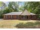 Charming single-story brick home featuring black shutters, a front lawn, and mature trees providing ample shade at 1513 White Ridge Dr, Rock Hill, SC 29732