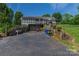 Home exterior featuring a driveway, garage, wooden railings, and an upper-level screened porch at 174 Perrin Dr, Mooresville, NC 28117