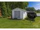 Backyard view of a white storage shed with gray double doors at 174 Perrin Dr, Mooresville, NC 28117