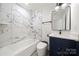 Updated bathroom featuring marble tile shower and sleek vanity with a modern faucet and fixtures at 1820 Shannonhouse Dr, Charlotte, NC 28215