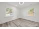 Neutral bedroom with hardwood floors, two windows with blinds and clean white walls at 1820 Shannonhouse Dr, Charlotte, NC 28215