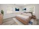 Staged bedroom with modern decor, light hardwood floors, rug, and a large bed at 1820 Shannonhouse Dr, Charlotte, NC 28215