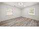 Neutral bedroom with hardwood floors, two windows with blinds and clean white walls at 1820 Shannonhouse Dr, Charlotte, NC 28215