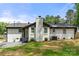 Back exterior of the home featuring white brick, black trim and back yard at 1820 Shannonhouse Dr, Charlotte, NC 28215