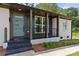 Welcoming front porch with dark trim, gray front door, and freshly painted white brick at 1820 Shannonhouse Dr, Charlotte, NC 28215
