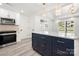 Modern kitchen features white cabinetry, stainless steel appliances, and a stylish blue island with gold accents at 1820 Shannonhouse Dr, Charlotte, NC 28215