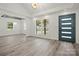 Spacious living room with wood-look floors, white trim, tray ceiling, and modern light fixture at 1820 Shannonhouse Dr, Charlotte, NC 28215