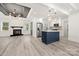 Open floor plan showcasing modern kitchen, living room with fireplace, wood-look floors and modern lighting at 1820 Shannonhouse Dr, Charlotte, NC 28215