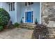 Inviting blue front door with decorative trim, stone steps, and manicured shrubs at 192 Diana Dr, Mount Gilead, NC 27306