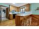 Well-lit kitchen boasts wooden cabinets, a tiled countertop, and a breakfast bar with stool seating at 192 Diana Dr, Mount Gilead, NC 27306