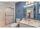Cozy blue bathroom featuring shower and tub combination, vanity, and framed mirror at 2026 Harvest Ln, Charlotte, NC 28210