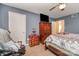 Cozy carpeted bedroom with wooden dresser, television, and doorway to a sunny area at 2026 Harvest Ln, Charlotte, NC 28210