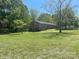 Expansive lawn and mature trees surround this brick home with bright, white-trimmed windows at 205 Rudolph Rd, Salisbury, NC 28146