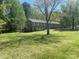 Expansive lawn and mature trees surround this brick home with bright, white-trimmed windows at 205 Rudolph Rd, Salisbury, NC 28146