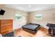 Bedroom with hardwood floors features a small tv and two windows for light at 213 Lakeview Dr, Harrisburg, NC 28075