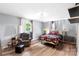 Bright bedroom featuring wood floors, neutral walls, lamps, and decor at 213 Lakeview Dr, Harrisburg, NC 28075