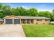 Charming brick ranch-style home with well-maintained lawn and two-car garage under a clear blue sky at 213 Lakeview Dr, Harrisburg, NC 28075
