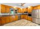 Well-lit kitchen featuring honey oak cabinets, stainless steel appliances, and wood-look flooring at 213 Lakeview Dr, Harrisburg, NC 28075