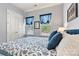 Comfortable bedroom featuring a cozy bed, bright windows with blue valances, and stylish decor at 213 Warbler Dr, Monroe, NC 28110