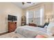 Serene bedroom featuring a comfortable bed, wicker dresser, and large windows with tranquil lighting at 213 Warbler Dr, Monroe, NC 28110