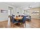 This dining room features a decorative ceiling fan, hard wood floors, and an adjacent living room area at 213 Warbler Dr, Monroe, NC 28110