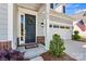 Front door with a wreath, sidelight, a two-car garage, and brick accents at 213 Warbler Dr, Monroe, NC 28110