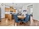 This eat-in kitchen includes seating, a dining room, and stainless appliances with hardwood flooring at 213 Warbler Dr, Monroe, NC 28110