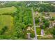 An aerial view showcases a lush green field, mature trees, and charming homes in a quiet neighborhood at 2474 Cedar Valley Dr, Conover, NC 28613